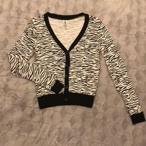 Zebra print cardigan with five buttons in front.